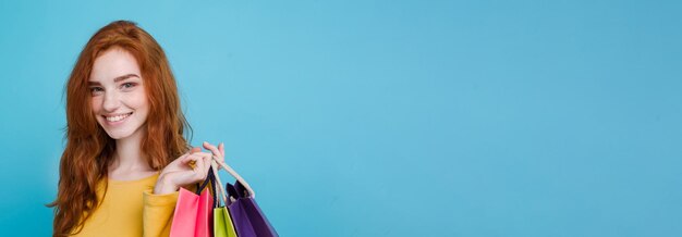Shopping concept close up portrait young beautiful attractive redhair girl smiling looking at camera
