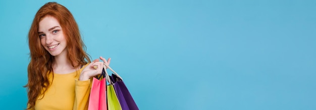 Shopping concept close up portrait young beautiful attractive redhair girl smiling looking at camera