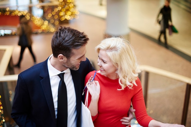 Shopping couple on the escalator in mall