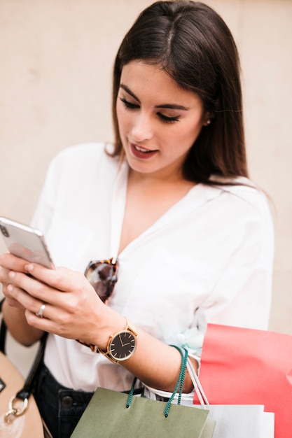 Shopping ragazza usando il suo telefono cellulare