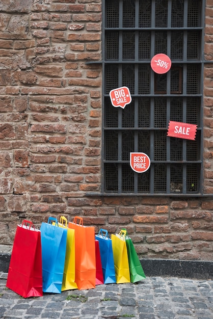 Foto gratuita i pacchetti di acquisto e le compresse di vendita si avvicinano alla finestra sul muro di mattoni