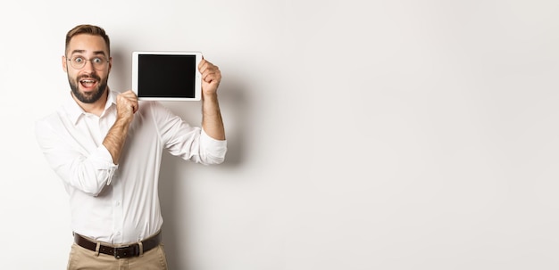 Shopping and technology handsome man showing digital tablet screen wearing glasses with white collar