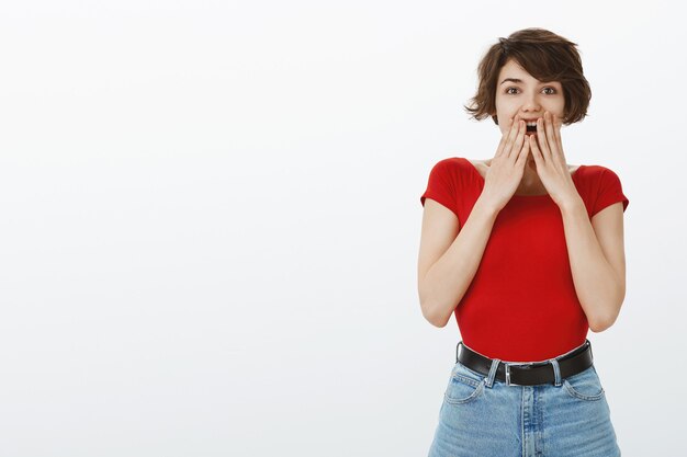 赤いTシャツでポーズをとる短い髪の少女