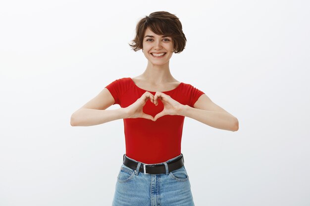 赤いTシャツでポーズをとる短い髪の少女