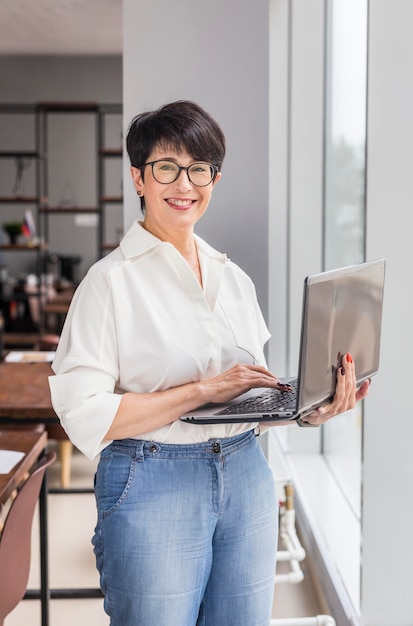 Short haired business woman using laptop and smiles