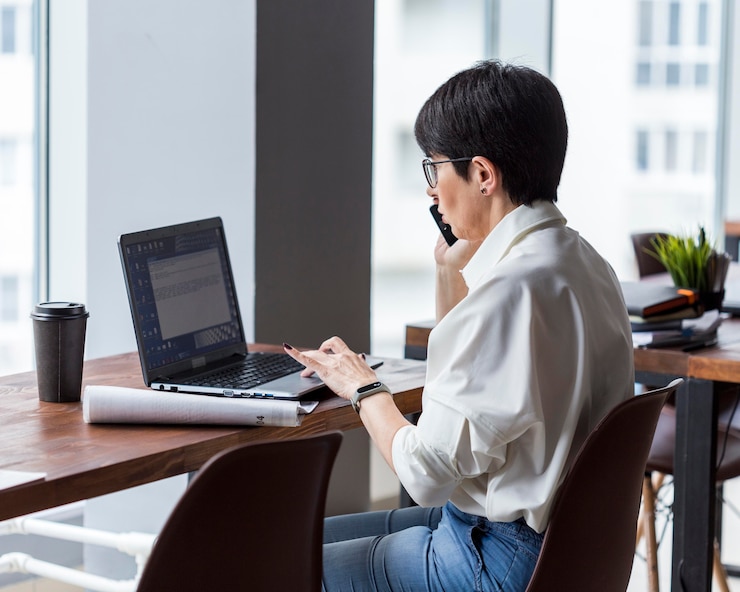 無料Photo 電話で働いて話している短い髪のビジネス女性