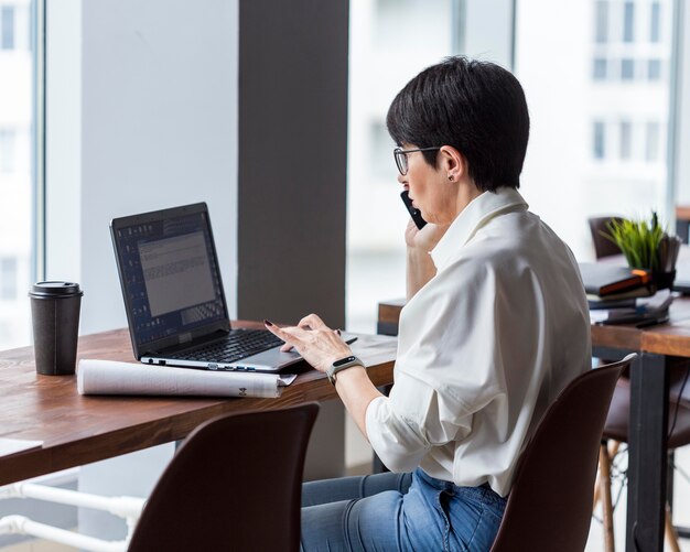 Short haired business woman working and talking on phone