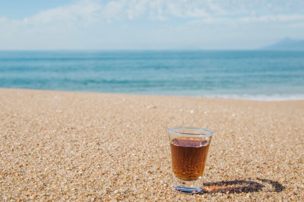 Shot of alcohol on sand