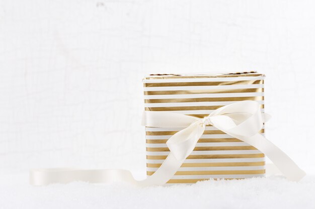 Shot of bright giftboxes decorated with ribbon laying on white snow