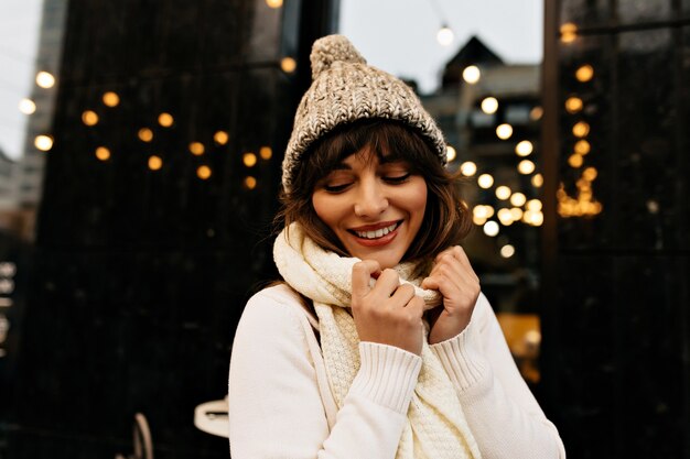 Shot of carefree woman with long brown hair and charming smile.