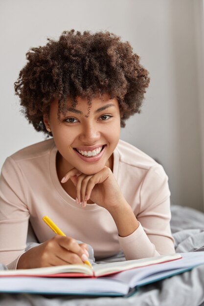 Shot of cheerful Afro American woman has toothy smile