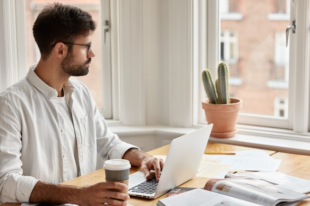 Shot of creative thoughtful male journalist working at home