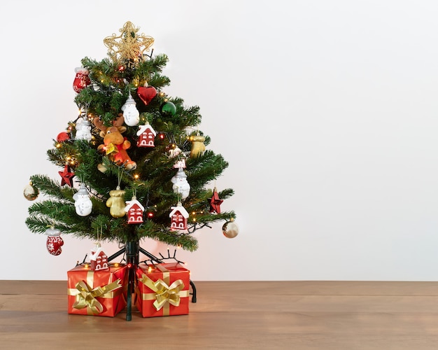 Foto gratuita colpo di un albero di natale decorativo con regali sotto di esso