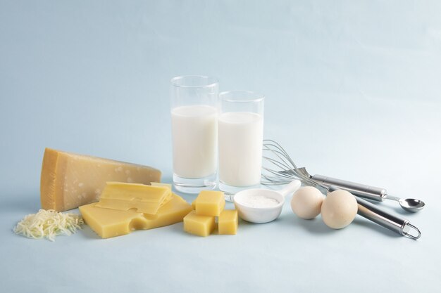 Shot of a delicious cheese platter with milk and eggs isolated on a light blue background
