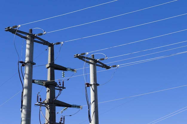 Shot of electric posts and lines against a blue background