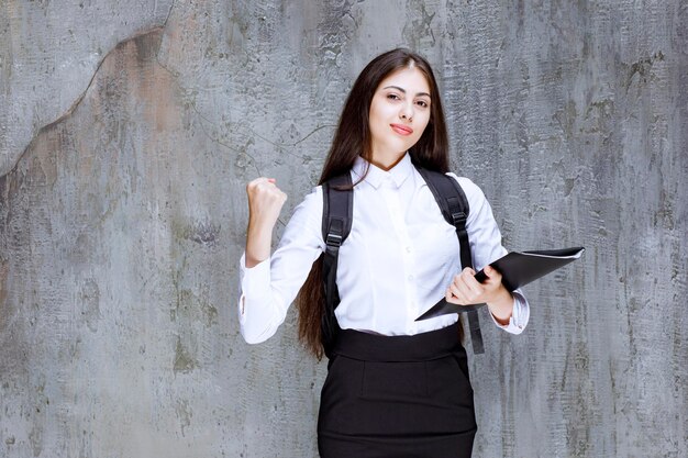 Shot of female student with backpack holding books. High quality photo