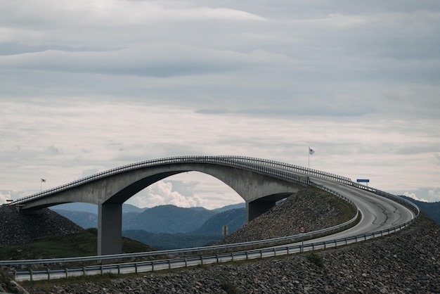 Shot of a long overpass road near mountains under the sky