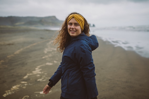 Free photo shot of a model enjoying the fresh air of the beach on a cold autumn day