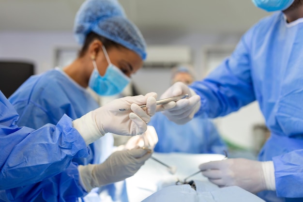 Free photo shot in the operating room assistant hands out instruments to surgeons during operation surgeons perform operation professional medical doctors performing surgery