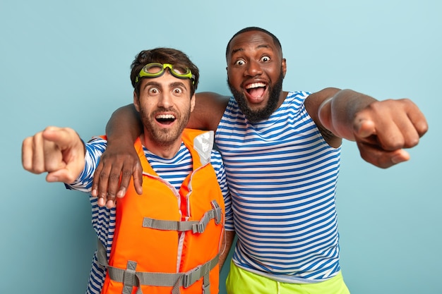 Shot of overjoyed friends posing with beach items