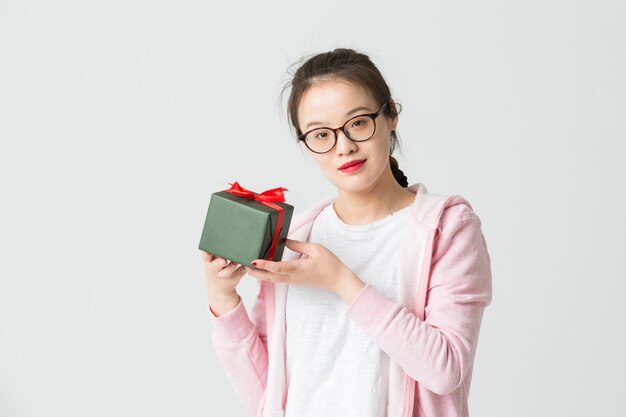 Shot in the studio of the young asian woman with a Christmas gift