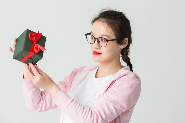 Shot in the studio of the young asian woman with a Christmas gift