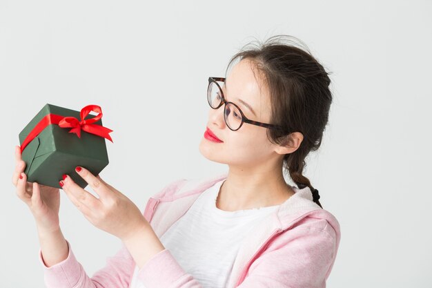 Shot in the studio of the young asian woman with a Christmas gift