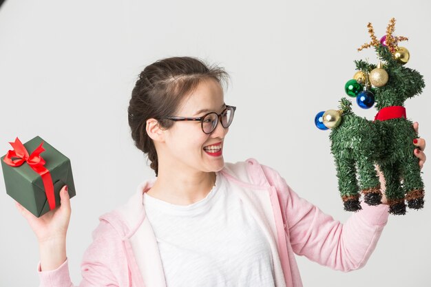 Shot in the studio of the young asian woman with a Christmas gift