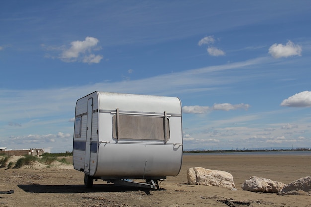 Free photo shot of a white, old  travel trailer on the ground