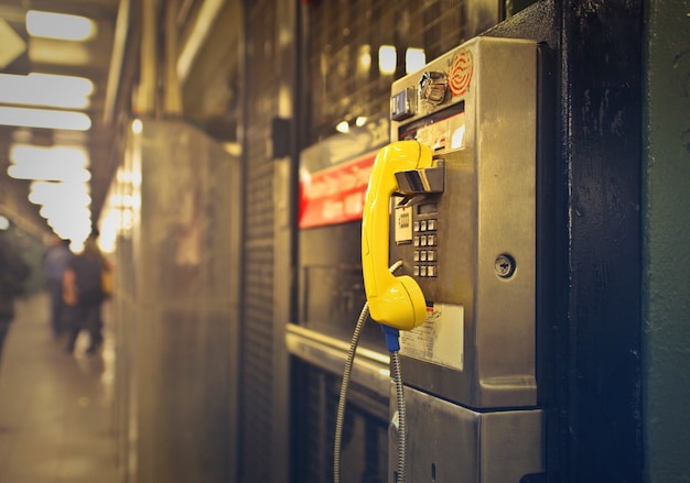 Shot of a yellow an gray payphone