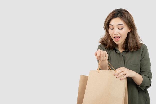 Shot of young female model looking inside of craft bags. High quality photo