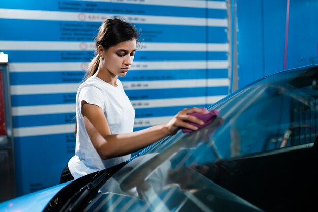 彼女の車を掃除している若い女性のショット