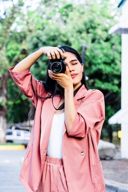 Free photo shot of a young woman with a photo camera - shooting process