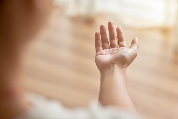 Over the shoulder of hand of unrecognizable person stretched forward begging for help