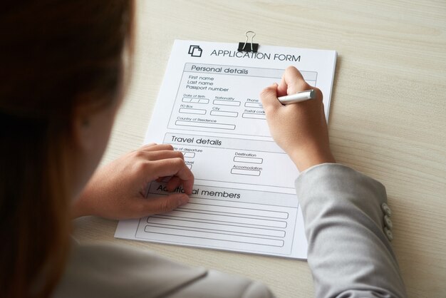 Over the shoulder shot of anonymous woman filling out the application form