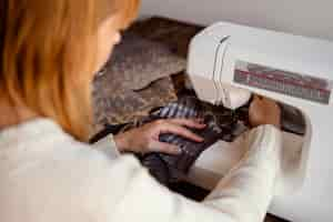 Free photo over the shoulder view tailor woman using sewing machine