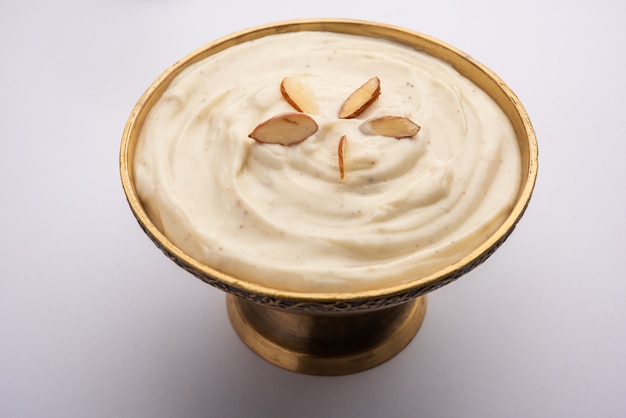 Shrikhand è un piatto dolce indiano a base di yogurt colato, guarnito con frutta secca