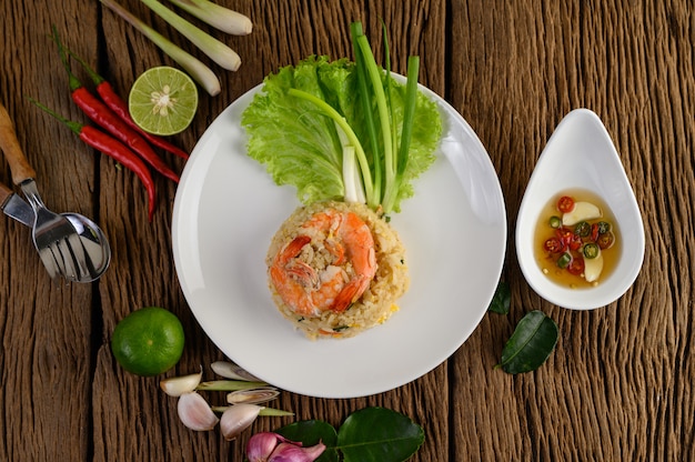 Shrimp fried rice on a white plate on a wooden table