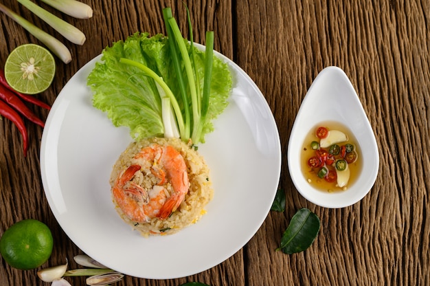 Shrimp fried rice on a white plate on a wooden table