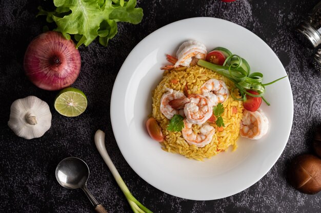 Shrimp fried rice with tomatoes, carrots and scallions on the plate