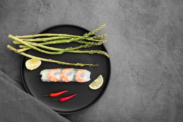 Shrimp rolls and asparagus on plate with sauce