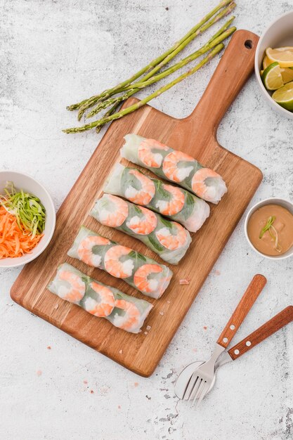 Shrimp rolls on chopping board with asparagus