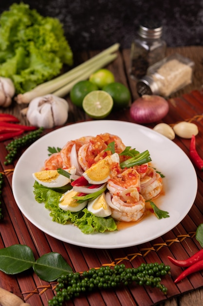 Free photo shrimp salad with boiled egg lettuce and chopped scallions in a white plate