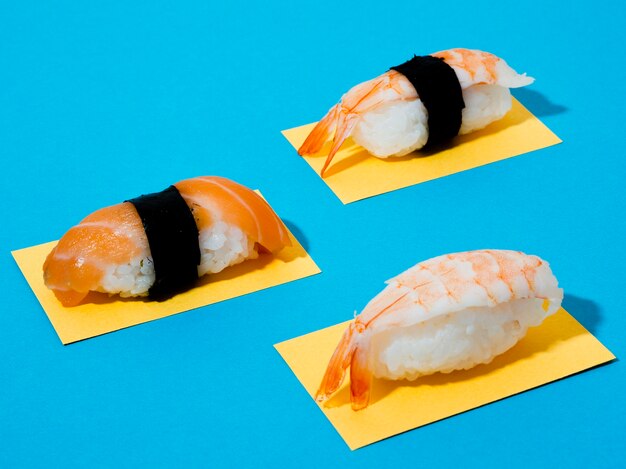 Foto gratuita sushi di salmone e gamberi su sfondo blu