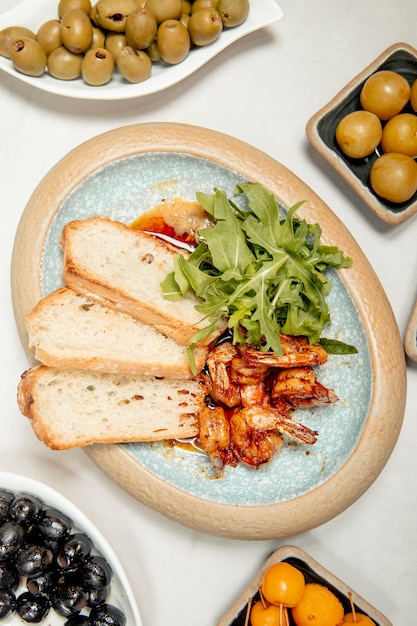 Free photo shrimps served with arugula and bread