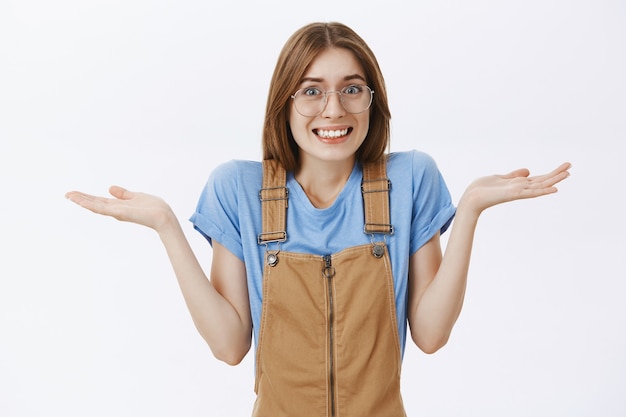 Shrugging clueless girl looking unaware or confused