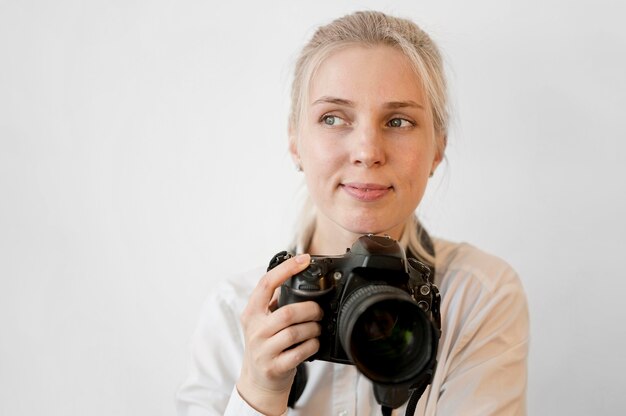 Shy cute girl holding a professional camera