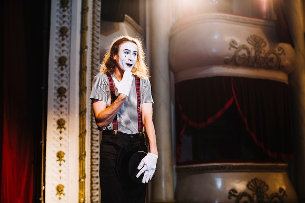 Shy male mime artist standing on stage in the auditorium