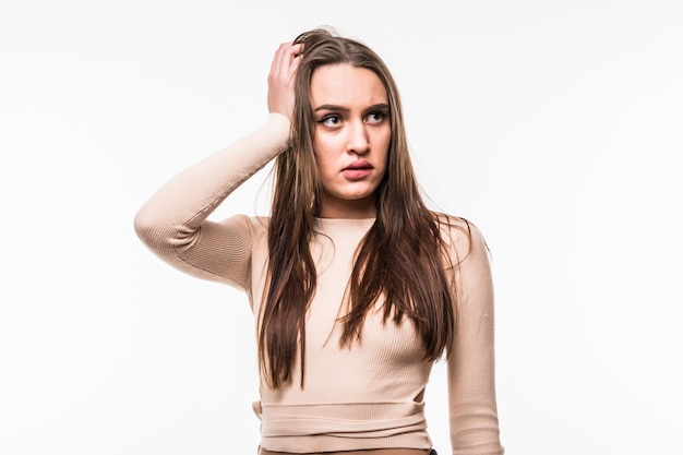 Shying young woman in bright t-shirt holds arm on her head isolated on white