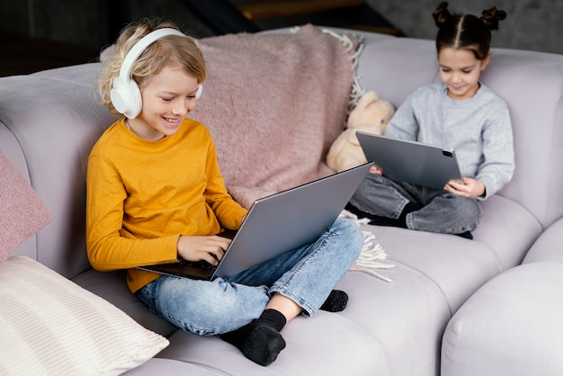 Free photo siblings on couch with laptop